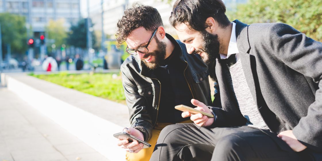 Zwei Personen nutzen die Händlereigene Loyalty-App und mobile-pocket auf dem Smartphone.